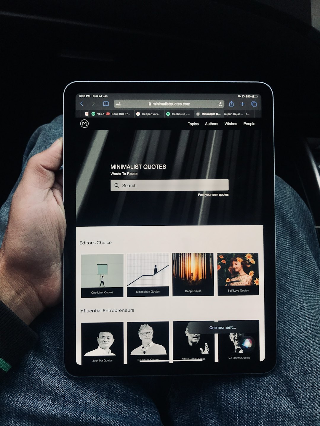 Osoba držiaca tablet s webovou stránkou zobrazujúcou citáty.
